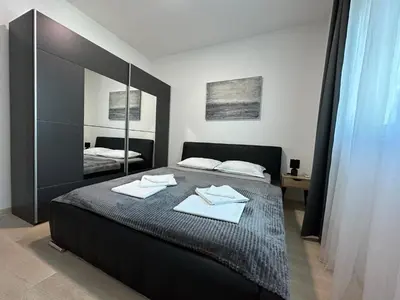 a bedroom with a bed with a large mirror at Ambassador Apartment Bečići with Private Garage Parking in Becici