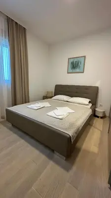 a bedroom with a large bed in a room at Ambassador Apartment Bečići with Private Garage Parking in Becici