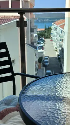 a table on a balcony with a view of a street at Ambassador Apartment Bečići with Private Garage Parking in Becici