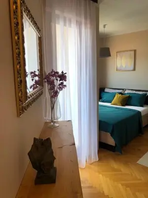 a bedroom with a bed and a vase of flowers on a table at Dream Studio in Budva