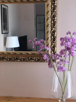 a vase with purple flowers in front of a mirror at Dream Studio in Budva