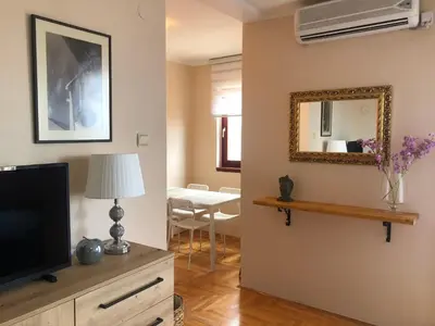 a living room with a television and a mirror at Dream Studio in Budva