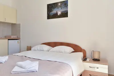 a bedroom with a large bed with white sheets at Apartmani Bojana in Budva