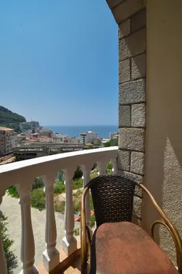 a balcony with a chair and a view of the ocean at Apartmani Bojana in Budva