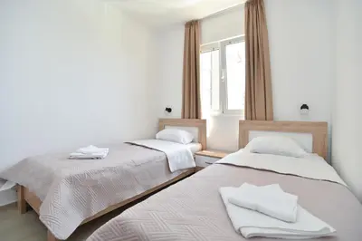 two beds in a room with a window at Apartmani Bojana in Budva