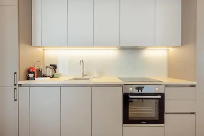 a kitchen with white cabinets and a sink at Villa Elle in Kotor