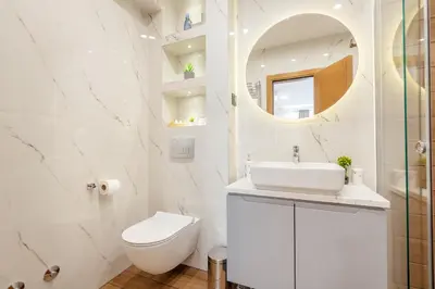 a white bathroom with a toilet and a sink at Villa Elle in Kotor