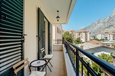 a balcony with a table and chairs on a building at Villa Elle in Kotor