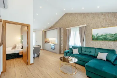 a living room with a green couch and a bedroom at Villa Elle in Kotor