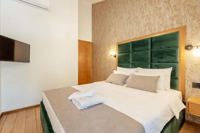 a bedroom with a large bed with a white towel on it at Villa Elle in Kotor