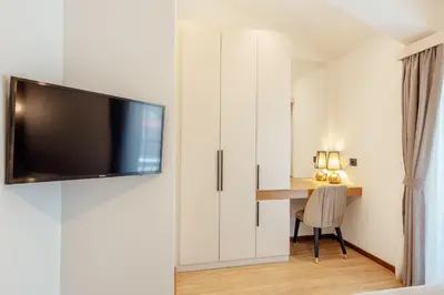 a bedroom with a desk and a tv on a wall at Villa Elle in Kotor