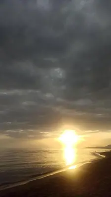 a sunset on the beach with the sun in the sky at Lemon Tree in Ulcinj