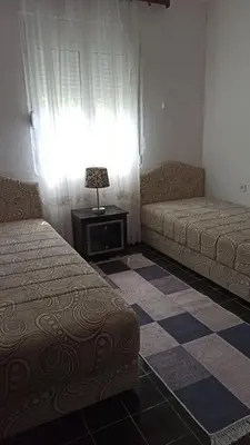 a room with two beds and a table and a window at Lemon Tree in Ulcinj