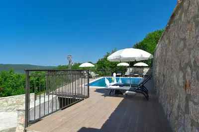 a deck with an umbrella and a swimming pool at Villa Andrea 1 in Budva