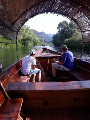 two men sitting on a boat in the water at Apartments Stankovic & Boat tours in Virpazar