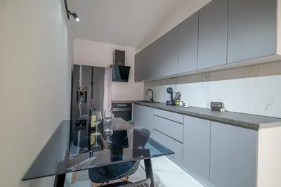a kitchen with a glass table and white cabinets at Sotto Sole apartment in Bar