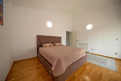 a bedroom with a bed and a wooden floor at Sotto Sole apartment in Bar
