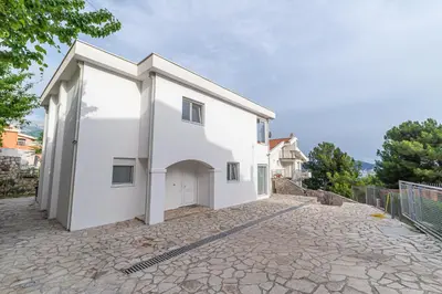 a white house with a garage on a stone driveway at Sotto Sole apartment in Bar