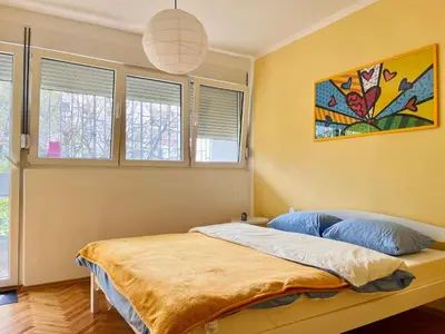 a bedroom with a bed in a room with windows at Old town in Podgorica