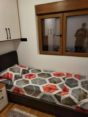 a bed with a quilt on it in a room at Lux Apartmani Bajova in Cetinje