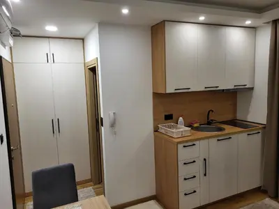 a small kitchen with white cabinets and a sink at Lux Apartmani Bajova in Cetinje