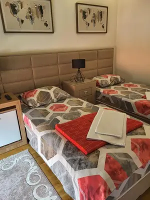 two beds in a bedroom with a laptop on top at Lux Apartmani Bajova in Cetinje