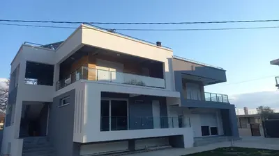 a white house with a lot of windows at Villa MERKURY in Sutomore