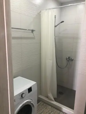 a bathroom with a shower and a washing machine at Villa MERKURY in Sutomore