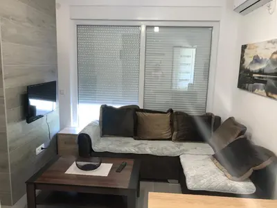 a living room with a couch and a table at Villa MERKURY in Sutomore