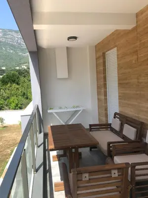 a room with a table and chairs on a balcony at Villa MERKURY in Sutomore