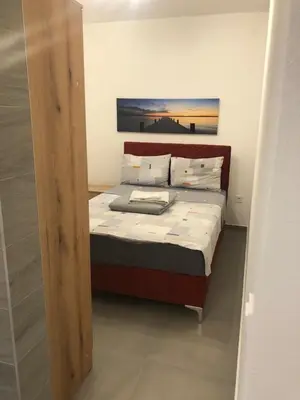 a bedroom with a bed with a wooden head board at Villa MERKURY in Sutomore