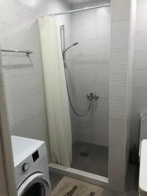a bathroom with a shower and a washing machine at Villa MERKURY in Sutomore