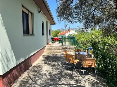a patio with a table and chairs on a house at Kaldrmica in Gornji Brčeli