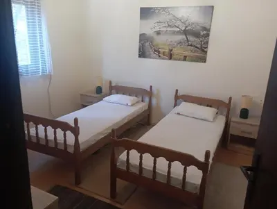 two beds in a room with a picture on the wall at Kaldrmica in Gornji Brčeli