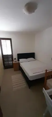a bedroom with a large bed and a window at Guest house Ruzica in Sutomore