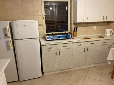 a kitchen with a white refrigerator and a window at Guest house Ruzica in Sutomore
