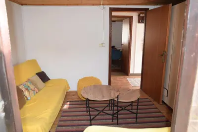 a living room with a yellow couch and a table at Family Guest House in Ulcinj