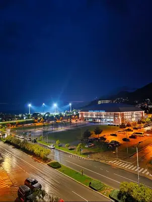 a city street with a building and street lights at night at Baby Blue Apartments in Bar