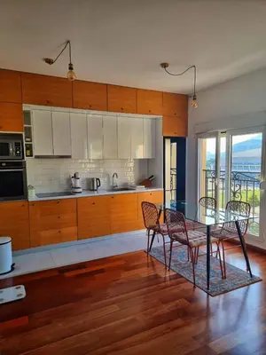 a kitchen with a table and chairs and a kitchen with a view at Baby Blue Apartments in Bar