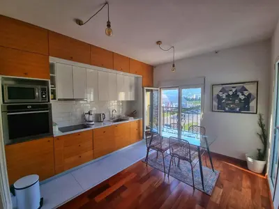 a kitchen with wooden cabinets and a glass table at Baby Blue Apartments in Bar