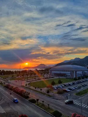 a sunset over a city with a parking lot and a building at Baby Blue Apartments in Bar