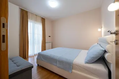 a hotel room with a bed and a window at Villa Stemi in Tivat