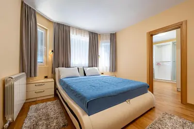 a bedroom with a large bed with a blue blanket at Villa Stemi in Tivat