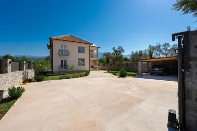 a driveway in front of a house with a car at Villa Stemi in Tivat
