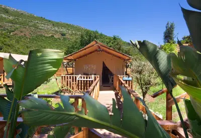 a wooden cabin with a porch and a mountain at Sea Glamping in Kotor