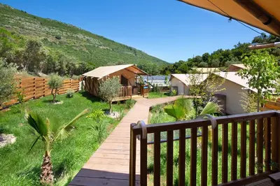 a wooden walkway in a yard with huts at Sea Glamping in Kotor