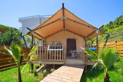 a gazebo in a field with a building at Sea Glamping in Kotor