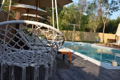 a swinging chair next to a swimming pool at Sea Glamping in Kotor
