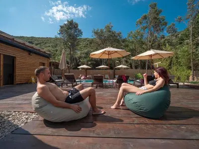 a man and woman sitting on bean bags near a pool at Sea Glamping in Kotor