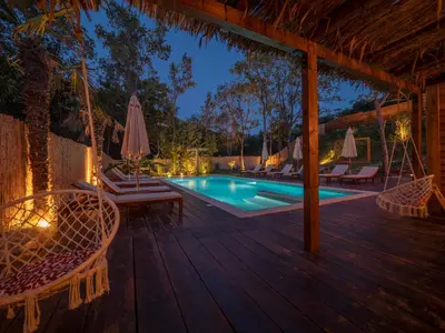 a deck with chairs and a swimming pool at night at Sea Glamping in Kotor